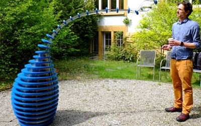 Der Sensor im Objekt nimmt eine Person in der nahen Umgebung wahr. Der Schlauch beugt sich langsam zur Person hin, die einen Becher in der Hand halten sollte. Die Karaffe am Ende des Schlauches neigt sich mit dem Gewicht des Wassers so weit, bis das Wasser aus dem Behälter im Objekt in den Becher der Person fliesst.  Der Sensor im Objekt nimmt eine Person in der nahen Umgebung wahr. Der Schlauch beugt sich langsam zur Person hin, die einen Becher in der Hand halten sollte. Die Karaffe am Ende des Schlauches neigt sich mit dem Gewicht des Wassers so weit, bis das Wasser aus dem Behälter im Objekt in den Becher der Person fliesst.