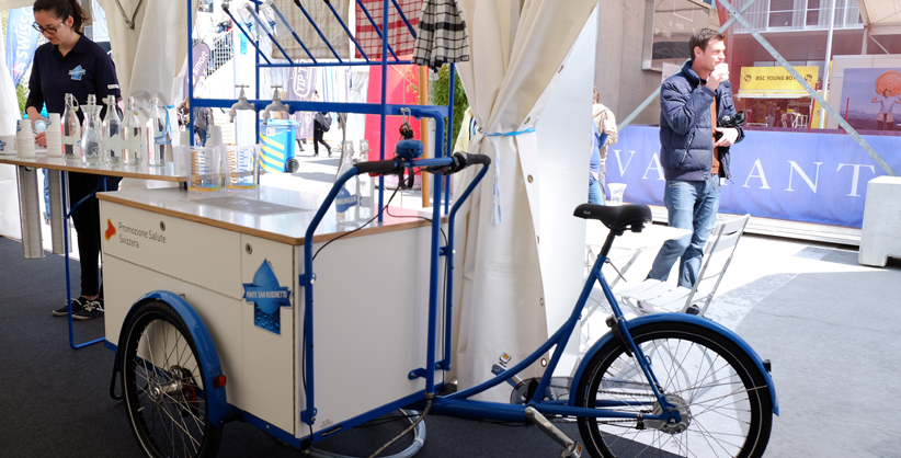  ausschenken Höhe: ca. 2 Meter Gewicht: ca. 100 kg Platzbedarf: ca. 6 m² Installationszeit: ca. 30 Minuten.     Art. 5 «Wasser-Velo»     So funktionierts: Beim Aufdrehen des Wasserhahns fliesst das Trinkwasser in die Karaffen oder Wasserflaschen der Besucherinnen und Besucher. 